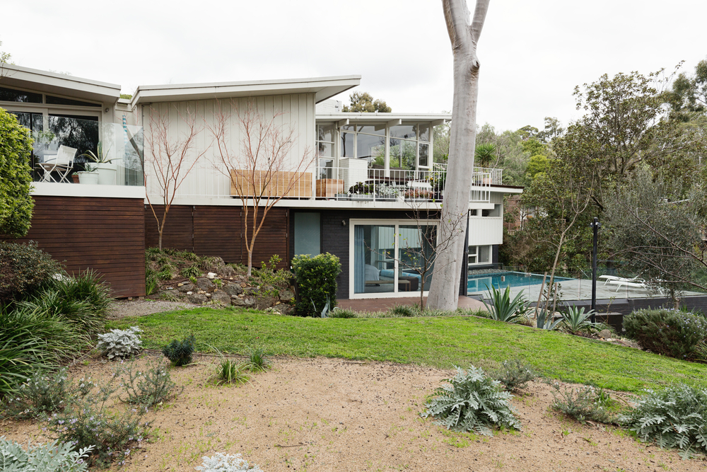 A mid-century home with angular butterfly roof slanting outward