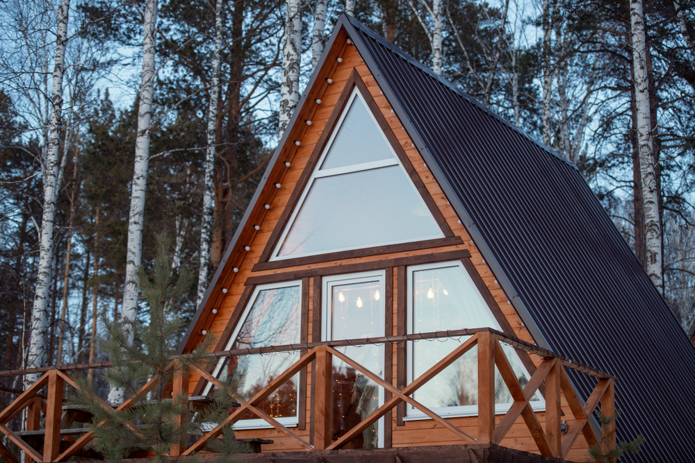 A cabin in the woods with a steep A-frame roof style