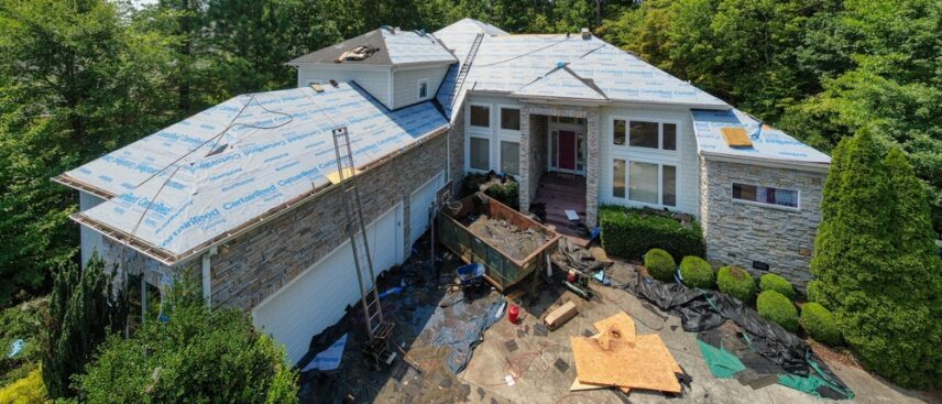 A large suburban home in the middle of a full roof replacement project