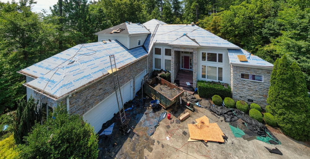 A large suburban home in the middle of a full roof replacement project