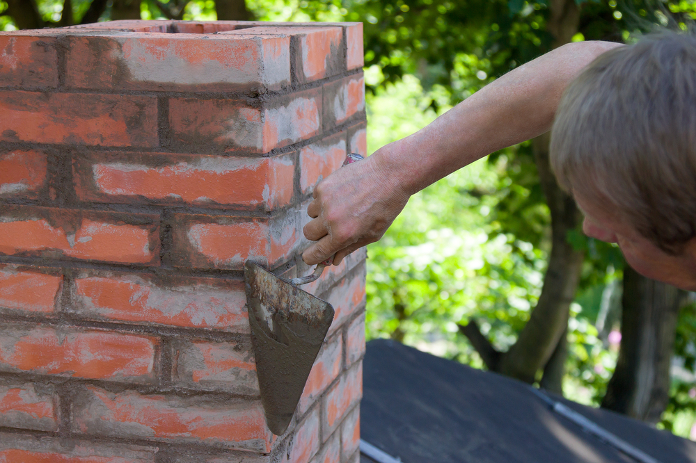 A tuckpointer putting the finishing touches on a new chimney installation