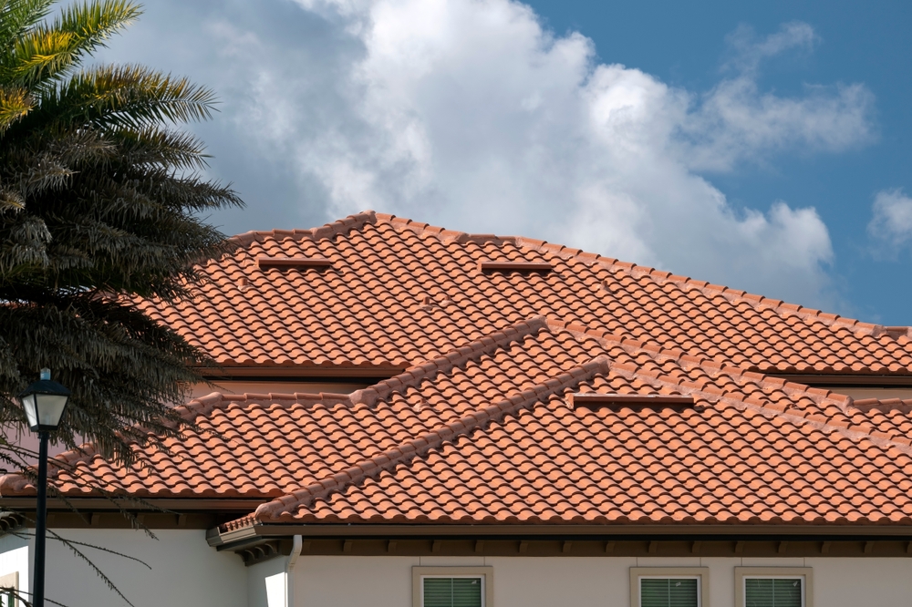 A large home with spanish style red tarracotta tile roofing