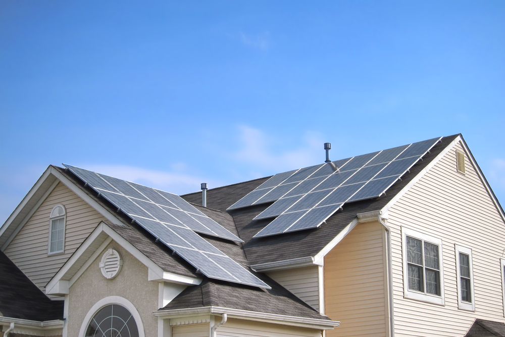 A residential home with two large sets of solar panels on their roof