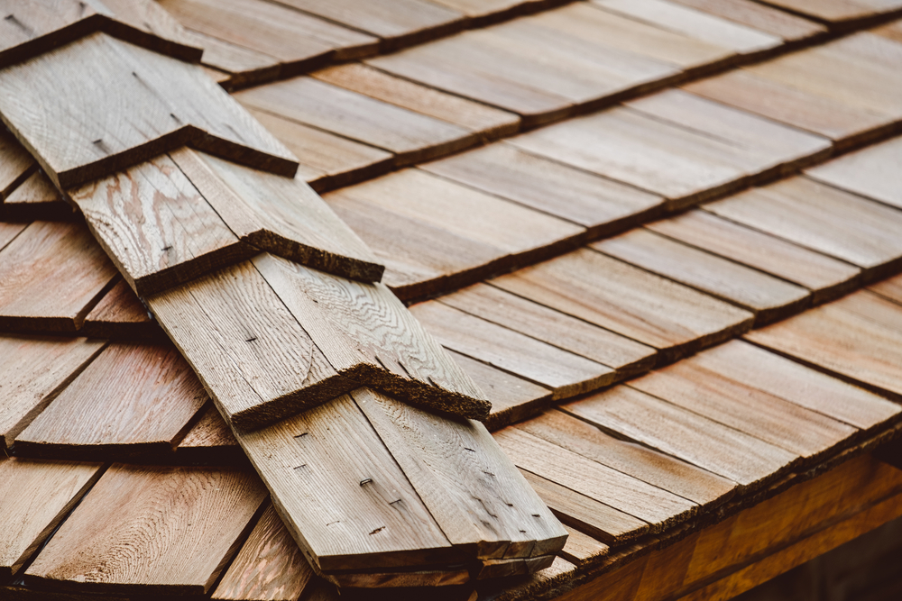 A close up of a roof with wood singles and wood hip caps