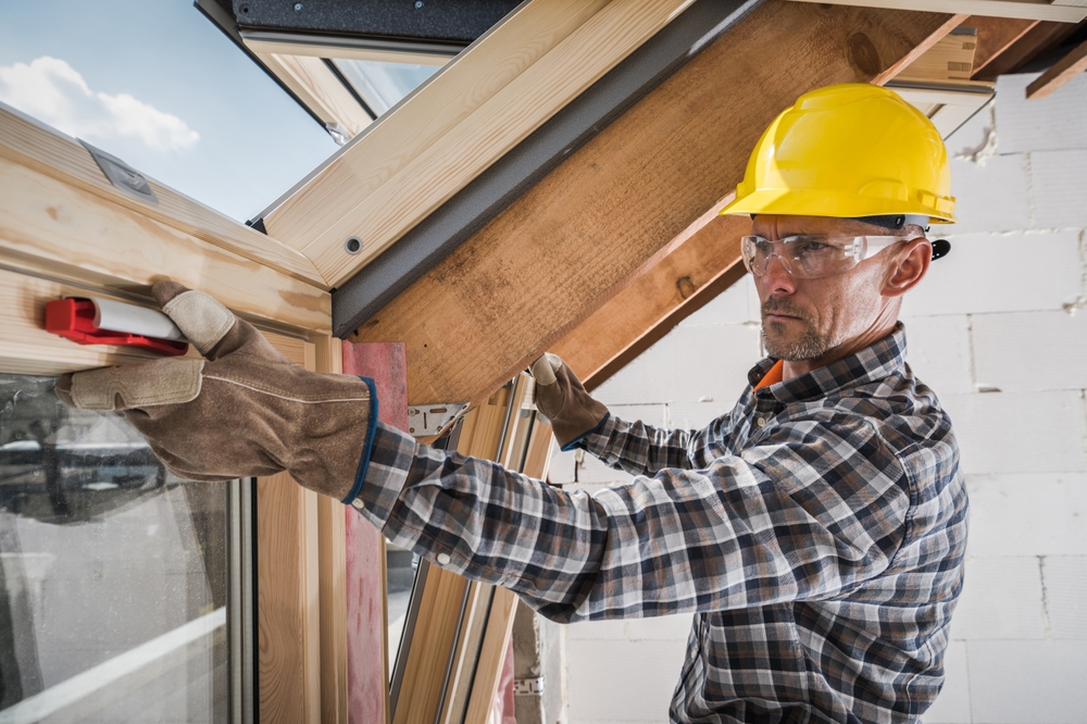 A contractor installs a skylight into a roof