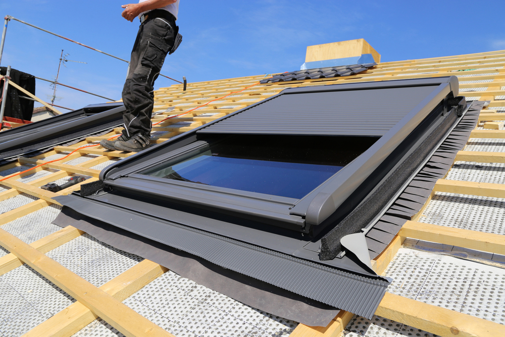 A contractor installs a skylight into a roof